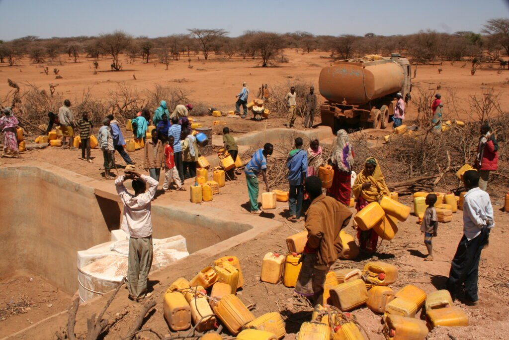 Image: Aid workers distributing water during a drought in the Horn of Africa. Privatization backers promised efficient delivery of public goods, but many communities still lack basic services